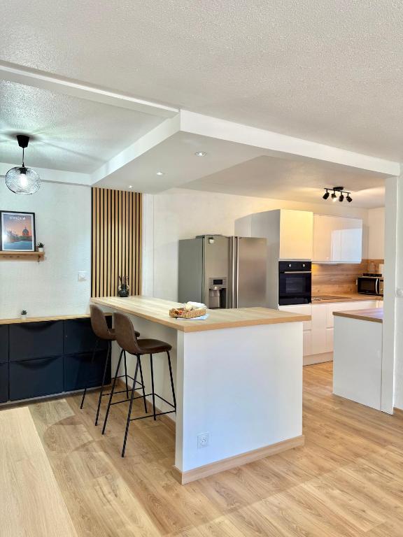 - une cuisine avec un îlot blanc dans une chambre dans l'établissement T2 Moderne - Quartier Cartoucherie - Proche Zénith & Purpan - Parking, à Toulouse