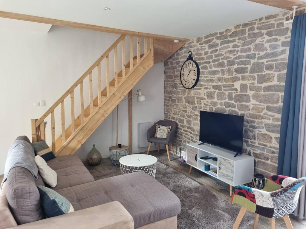 un salon avec un canapé et un mur en pierre dans l'établissement Gîte de Larina, à Hières-sur-Amby