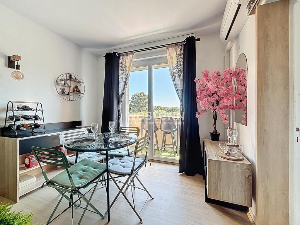 une salle à manger avec une table et des chaises et une fenêtre dans l'établissement 3743-T2 lumineux à 5 min de la plage, à Argelès-sur-Mer