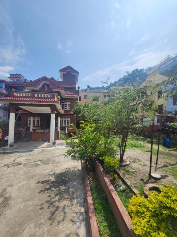 a group of buildings with trees in a courtyard at Yadav Niwas Homestay in Bālāju
