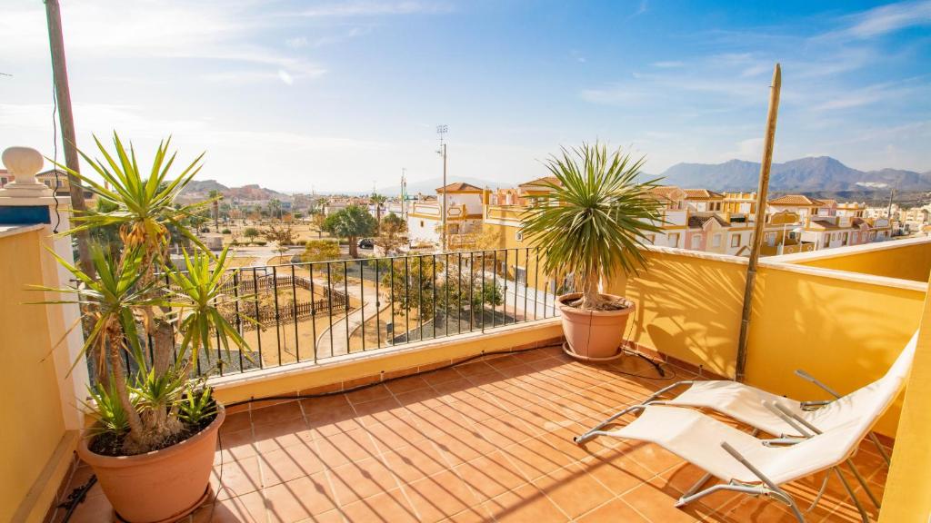 un balcón con una silla blanca y palmeras en Lira 1013, en San Juan de los Terreros
