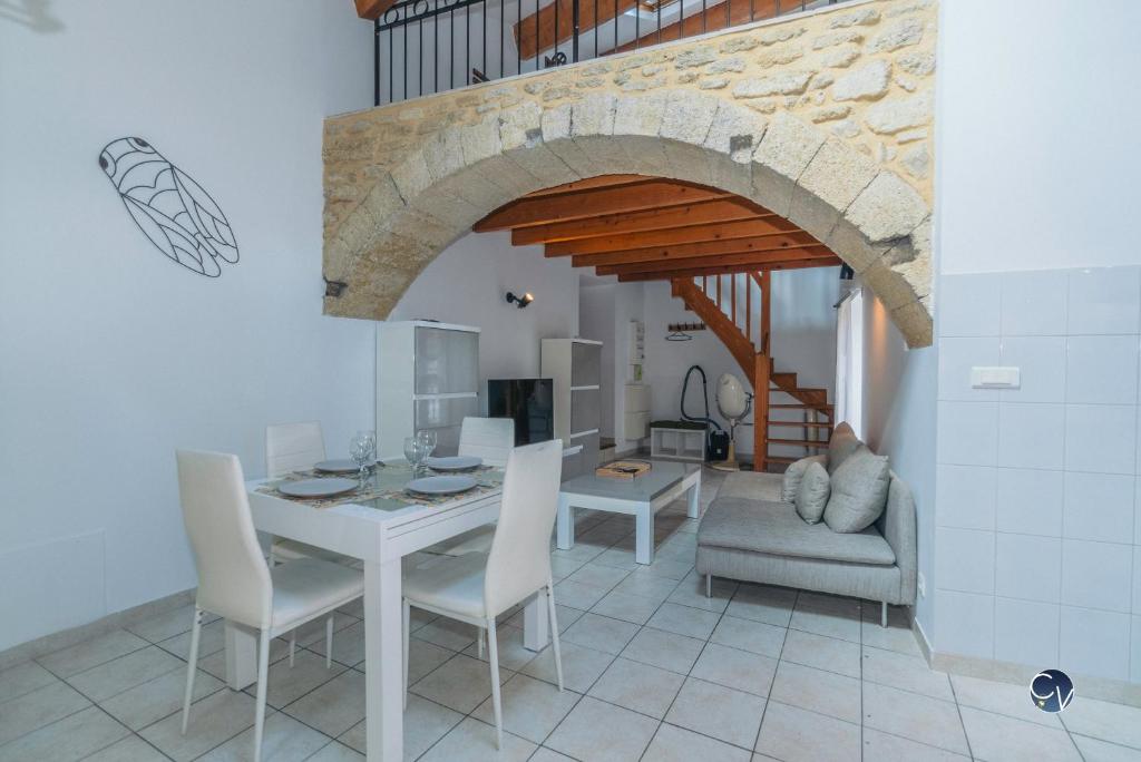 une cuisine et une salle à manger avec une table et des chaises dans l'établissement Joli appartement avec Mezzanine, à Roquemaure