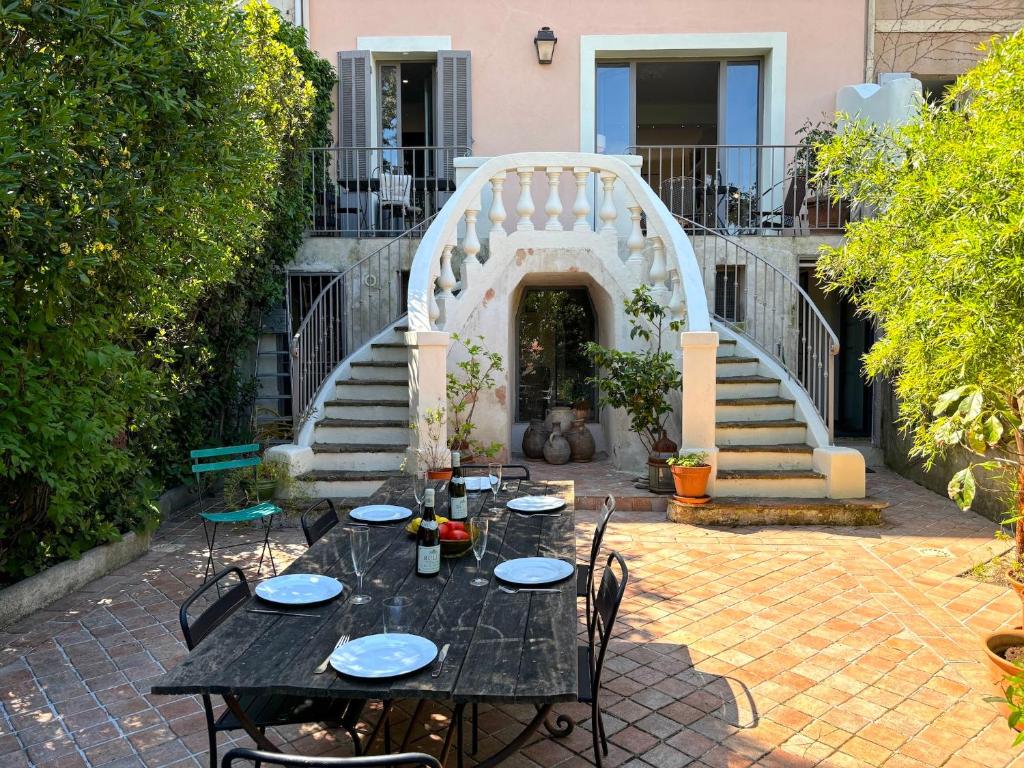 un patio avec une table et des chaises et un escalier dans l'établissement Villa Iza, à Toulon