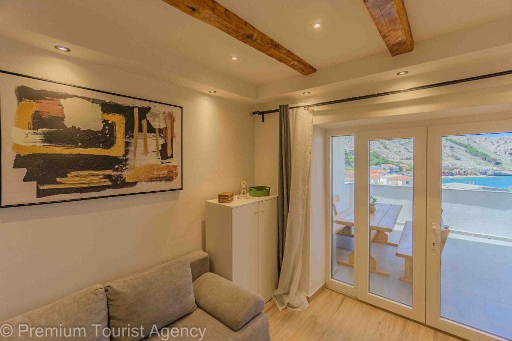 a living room with a couch and a sliding glass door at Toncica Sunny terrace with seaview and shaded BBQ area in Metajna