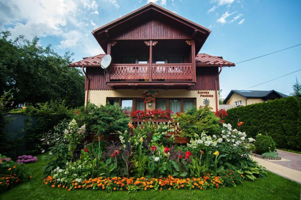 シュツァブニツァにあるSzarotka Pienińskaの花の庭が目の前にある家