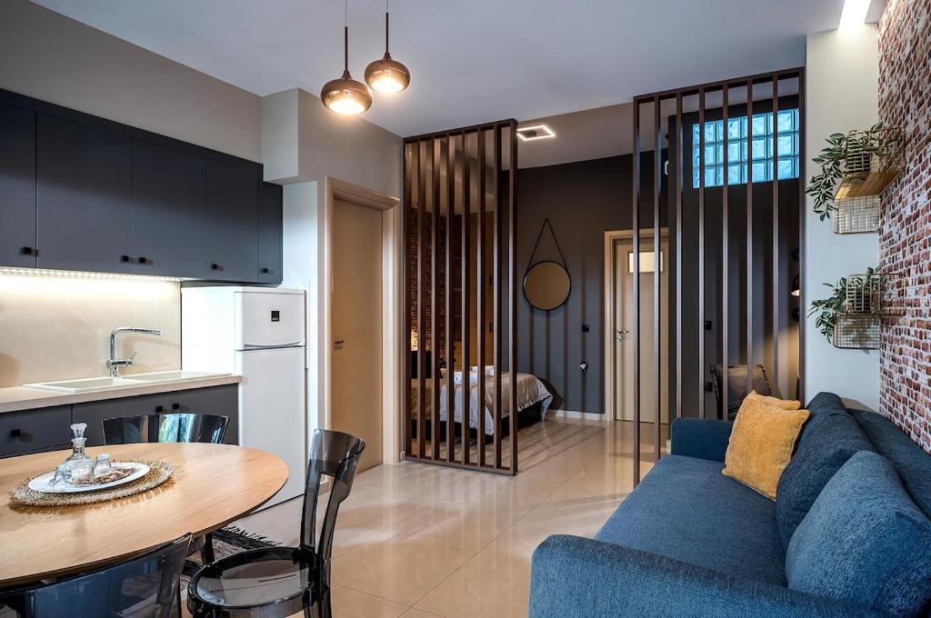 a living room with a blue couch and a table at Herophile apartment close to airport & city center in Néa Alikarnassós