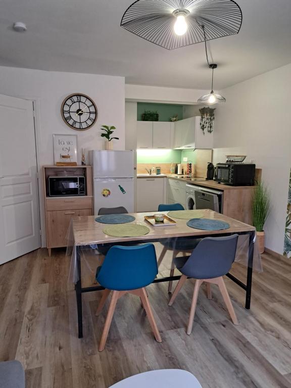 une cuisine avec une table en bois et des chaises bleues dans l'établissement Appartement Calme et idéalement situé, à Port-Vendres