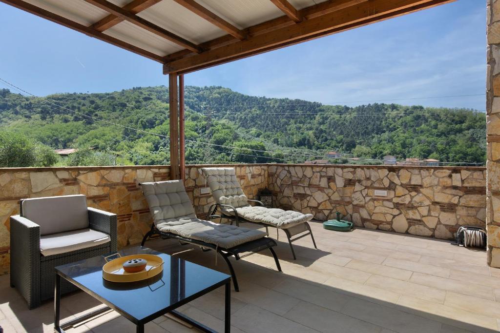 un patio con sedie e un tavolo e un muro di pietra di La Dolce Vita a Quiesa