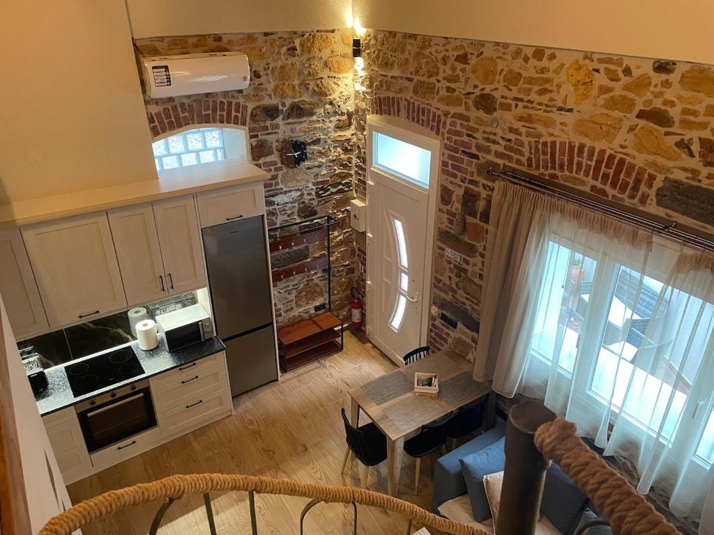 a kitchen with a stone wall and a table at Downtown ViAlla in Chios