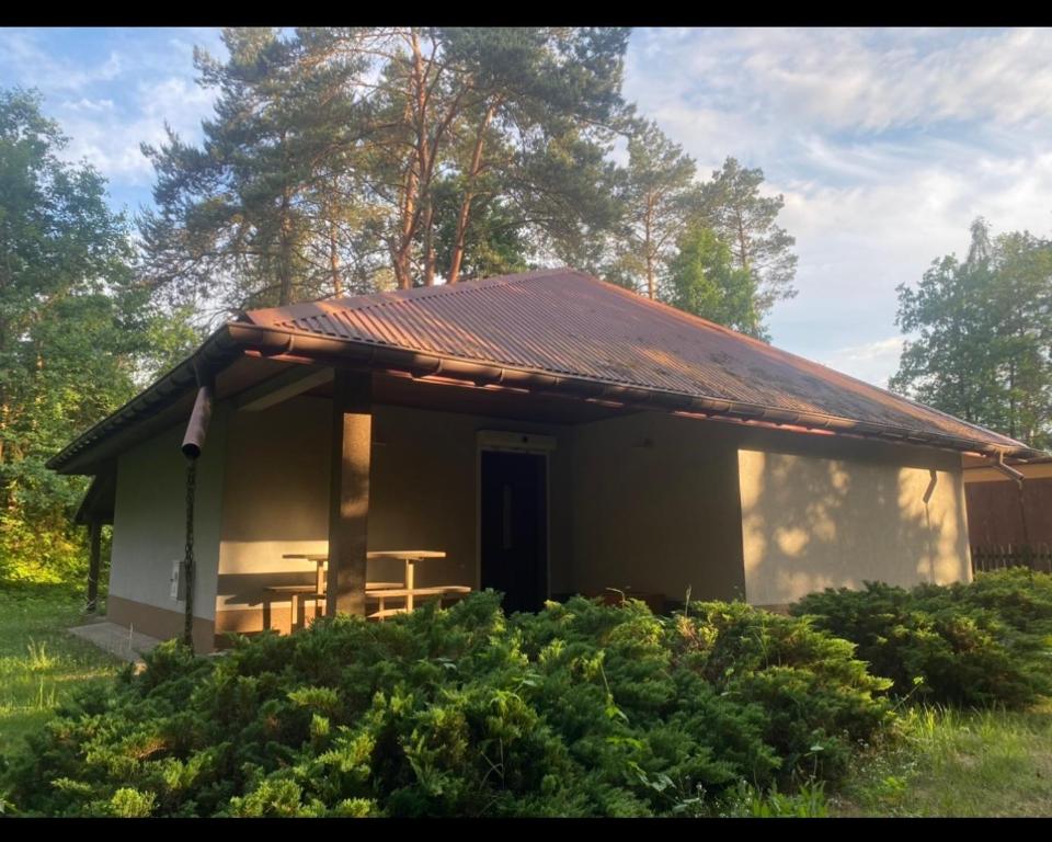a small house with a table and a roof at Domek letniskowy in Radawa