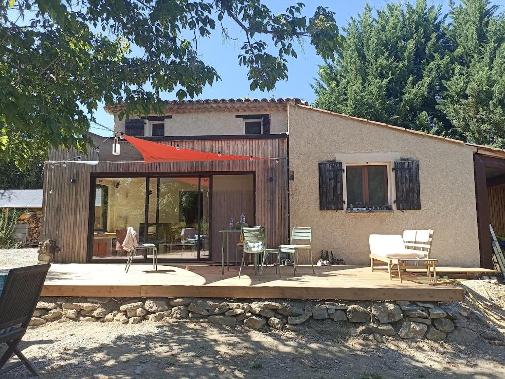 une maison avec un patio avec des chaises et une table dans l'établissement Maison Pierrerue, à Pierrerue