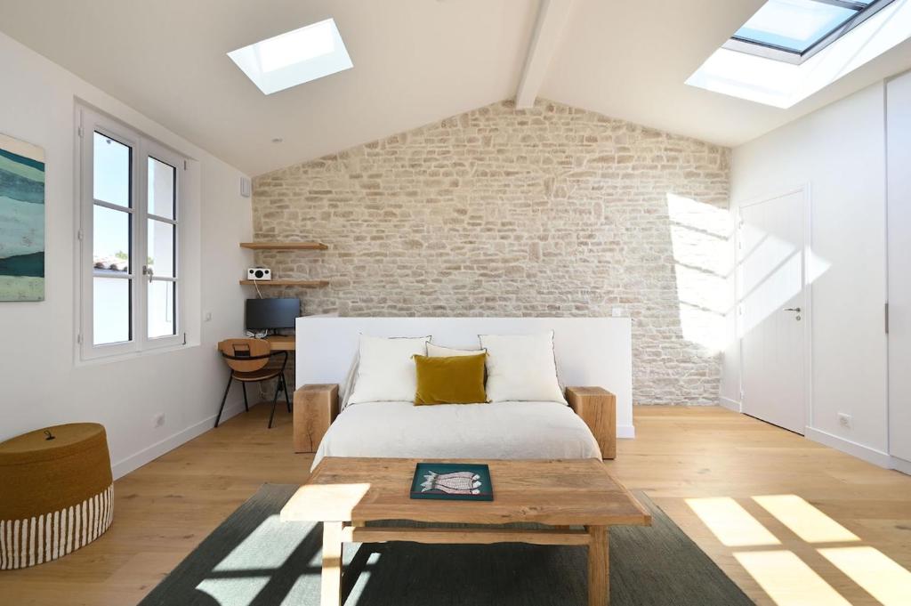 une chambre avec un lit et un mur de briques dans l'établissement 504 La suite caractère et élégance, à Ars-en-Ré