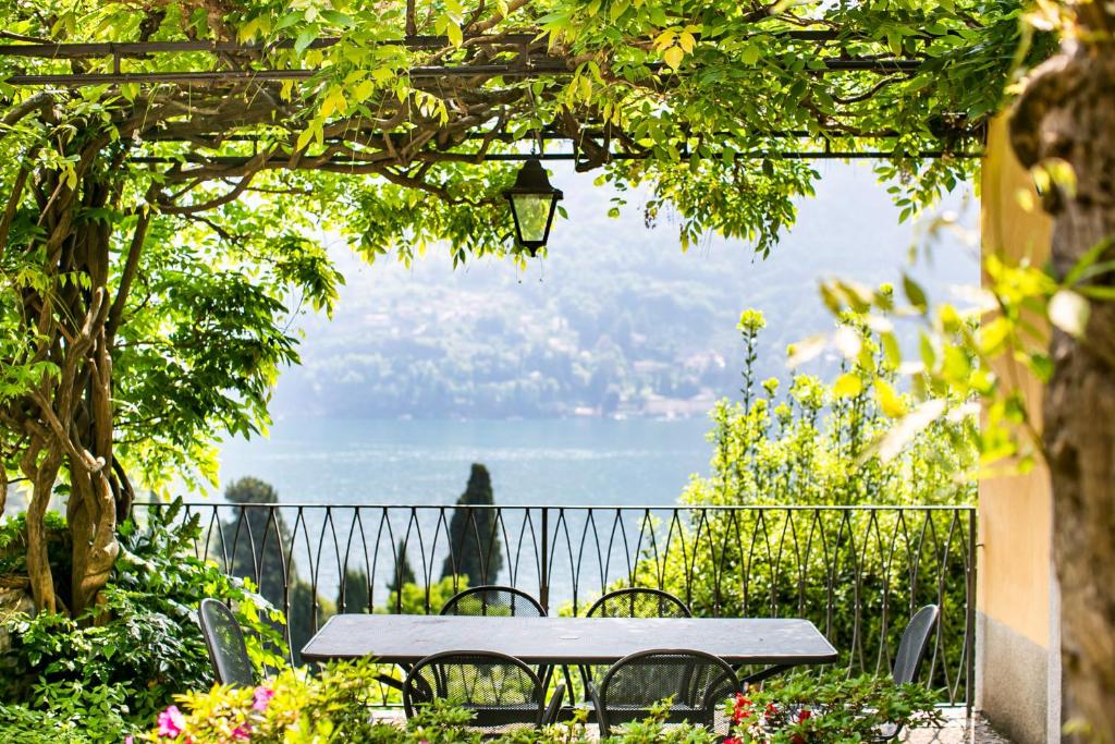 une table et des chaises sous une pergola dans un jardin dans l'établissement Appartamento in Villa Fioravante by Wonderful Italy, à Moltrasio