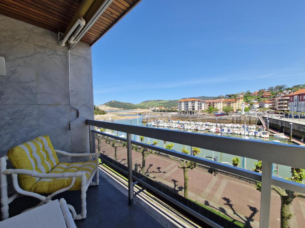a balcony with a chair and a view of the beach at VISTAS MAR Y PUERTO Plentzia - 200m2 y Parking in Plentzia