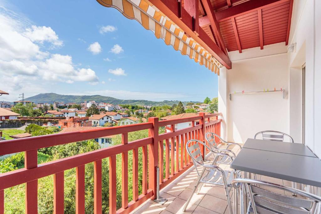un balcon avec une table et des chaises et une vue dans l'établissement Biantenia B23 Appartement avec balcon et parking sur les hauteurs, à Hendaye