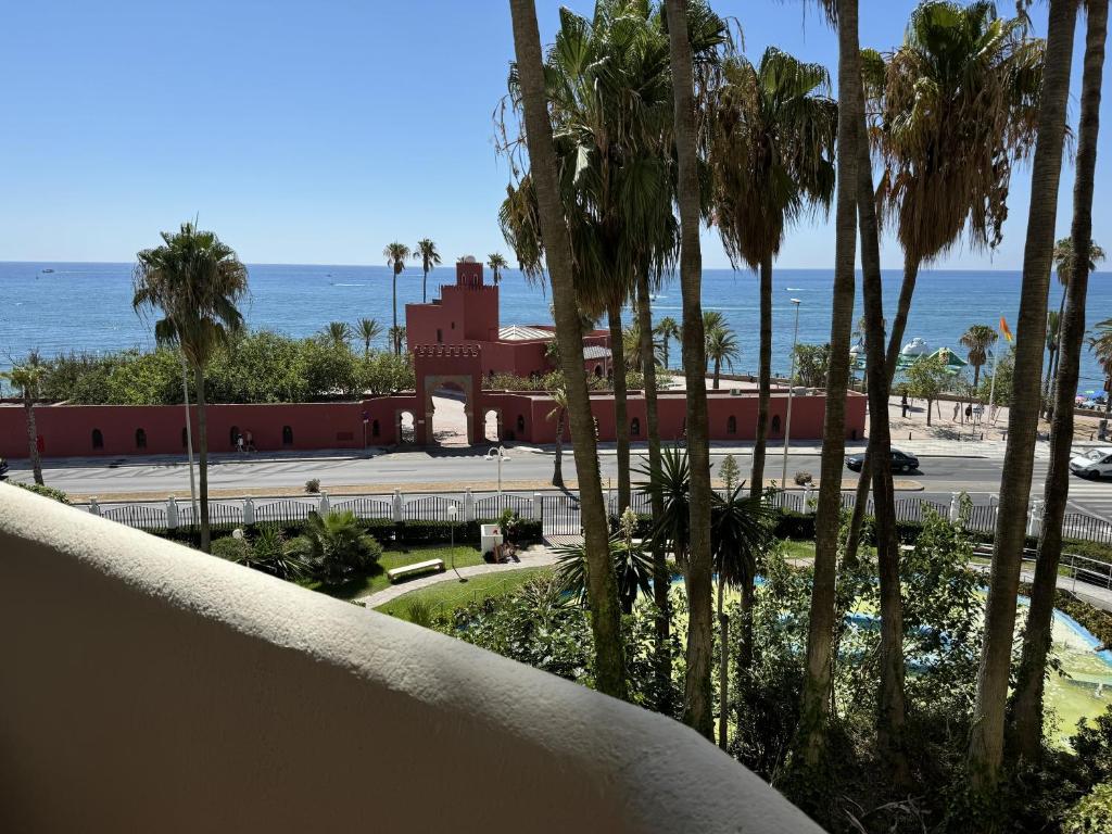 Blick auf ein Resort mit Palmen und das Meer in der Unterkunft Benalbeach con vistas al mar in Arroyo de la Miel