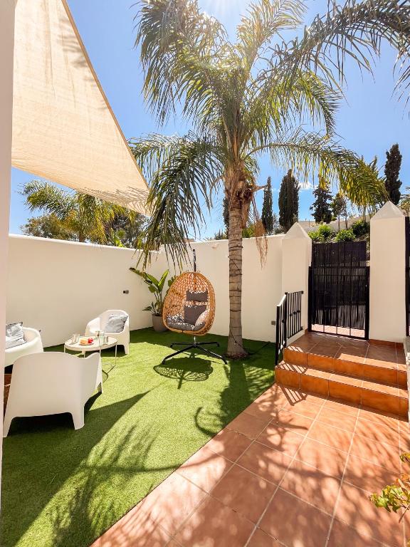 a garden with a palm tree and a patio at Chalet Relax con Piscina privada in Águilas