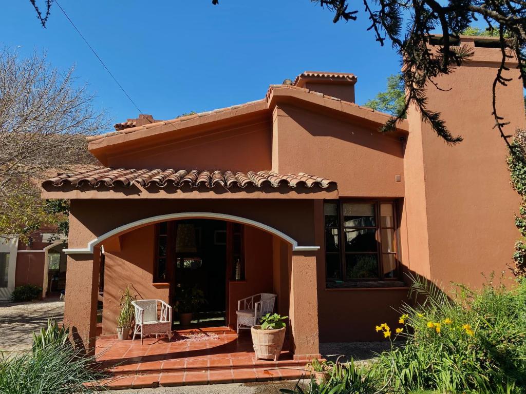 a house with two chairs in front of it at Estancia Urbana Hotel Boutique in Río Cuarto