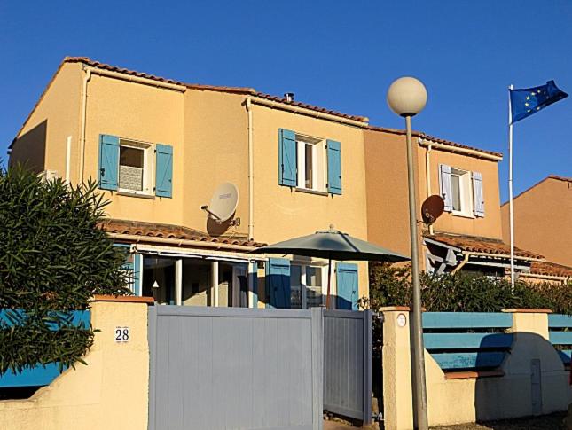 une maison avec une clôture blanche et un parasol dans l'établissement Mas de Perimont 28, à Fleury