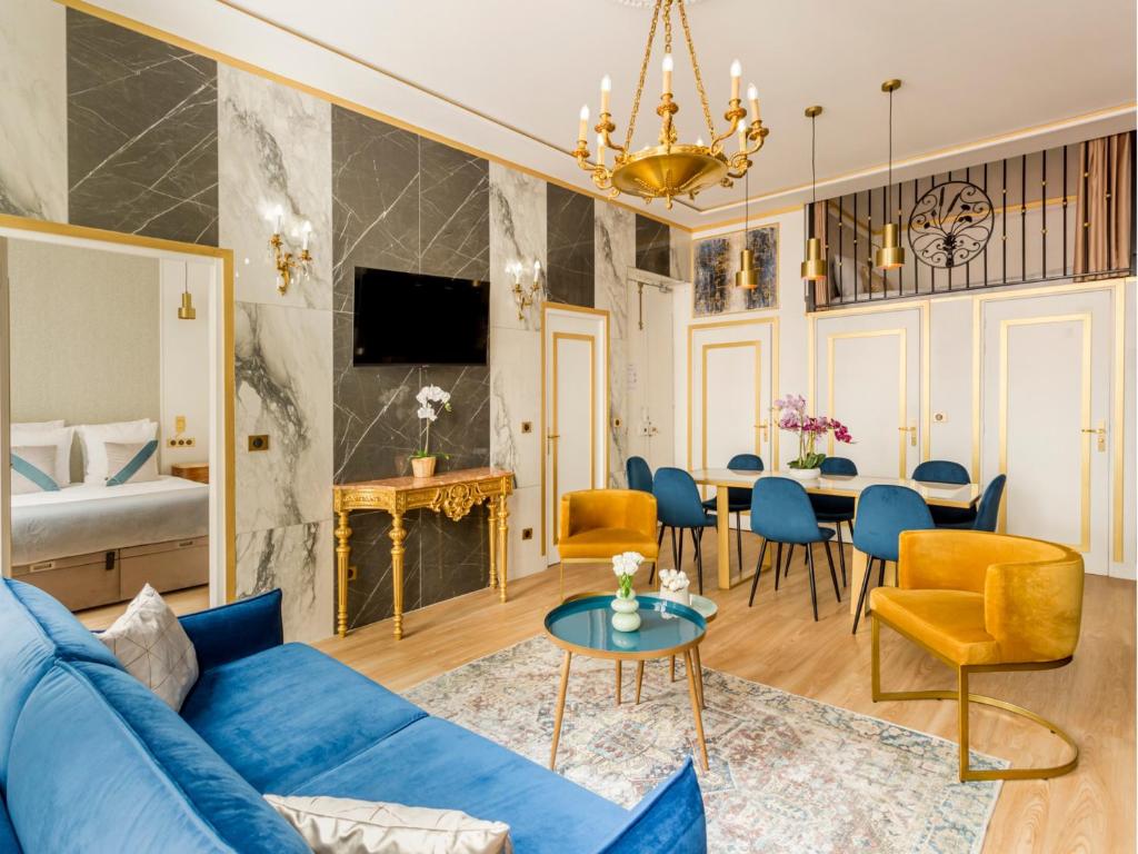 un salon avec un canapé bleu et une salle à manger dans l'établissement Merveil - Luxury Suite -ChampsElysees-Florentin II, à Paris