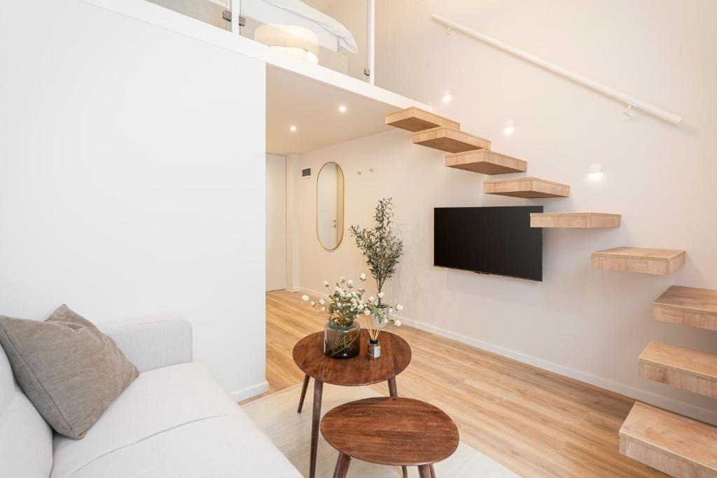 布达佩斯Szerb Boutique Suites, by BQA的带沙发和电视的客厅以及楼梯。