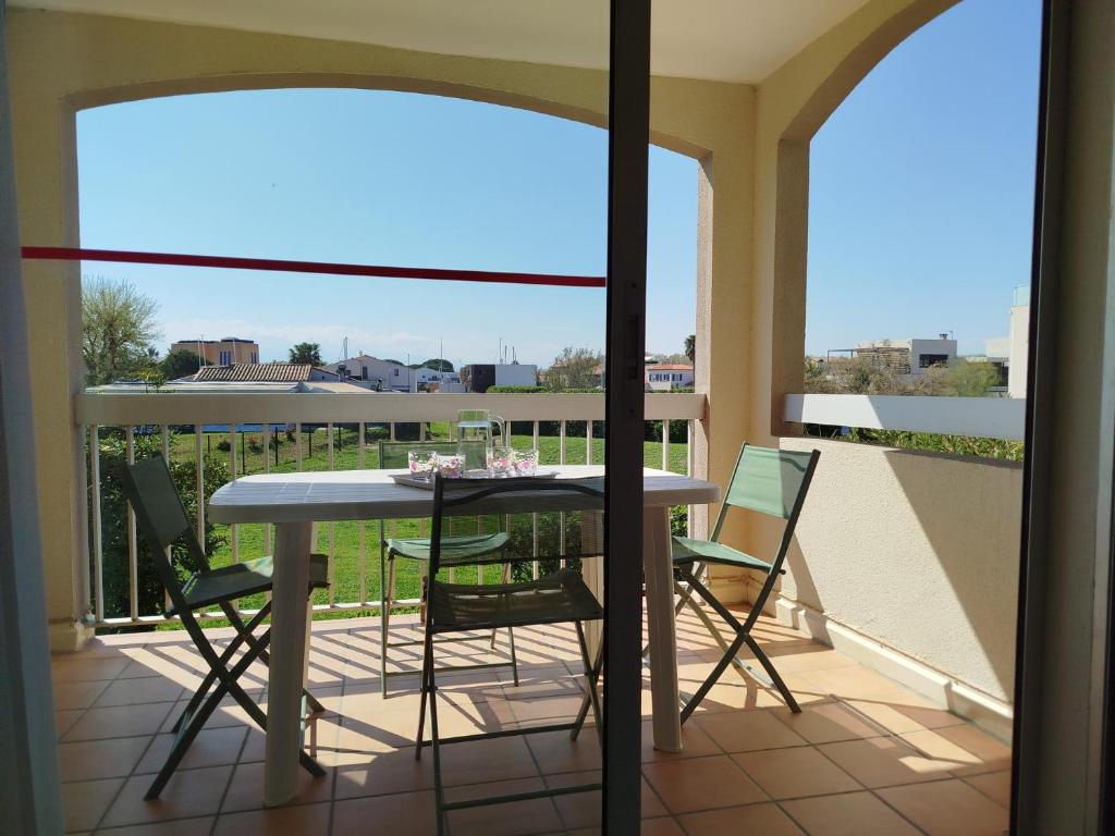 un balcon avec une table et des chaises dessus dans l'établissement Cadre verdoyant proche mer pour ce T2 avec terrasse - 4CAR113, à Saint-Cyprien