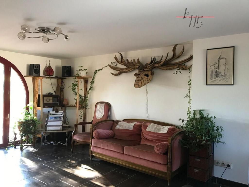 - un salon avec un canapé et des bois sur le mur dans l'établissement Le 115, retour aux sources, à Hadol