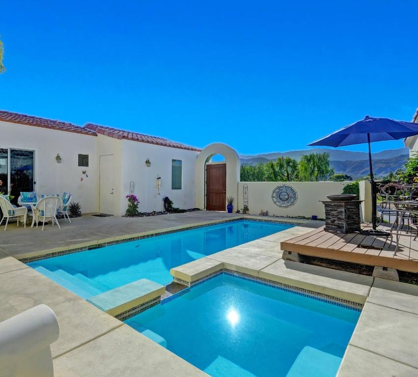 una piscina con patio y una casa en Hidden Jewel, en Cathedral City
