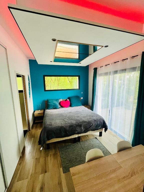 a bedroom with blue and pink walls and a bed at Studio chic & champêtre in Aussonne
