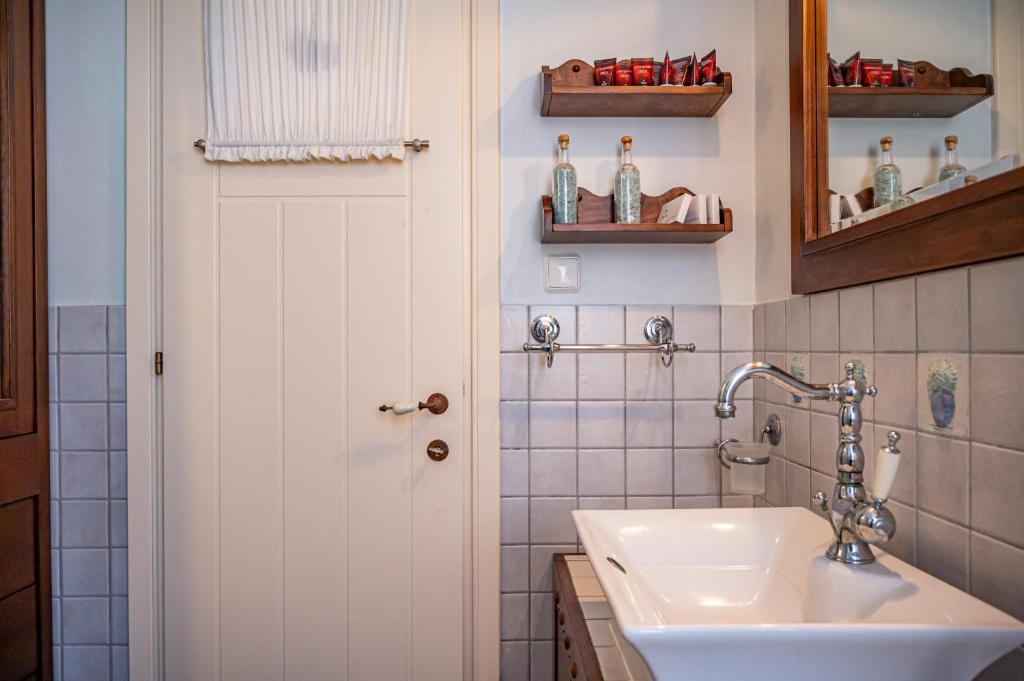 a bathroom with a sink and a white door at Emily's Luxury Suites in Pefkochori