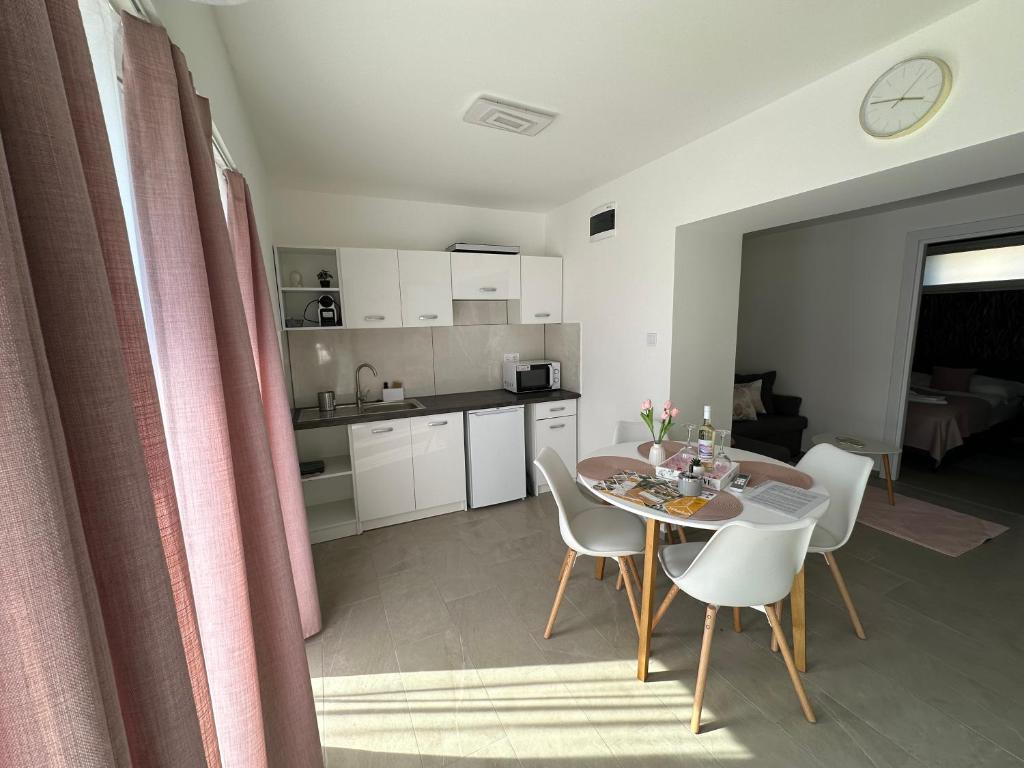 a kitchen and dining room with a table and chairs at Holdfény apartman in Makó