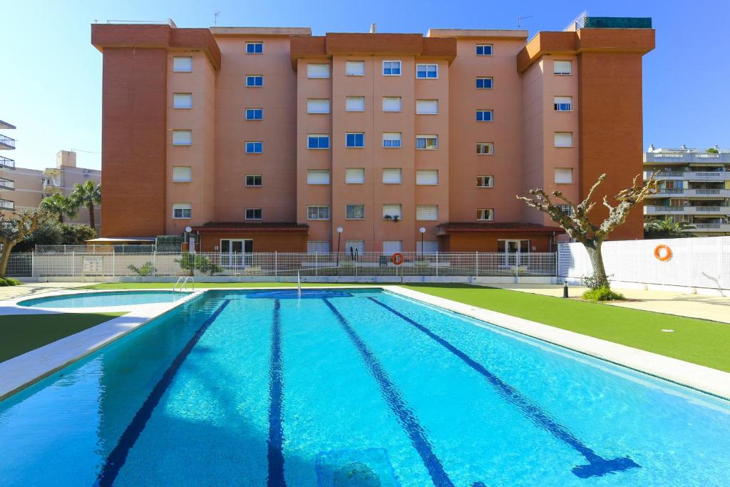 una piscina vacía frente a un edificio en Apartamento TECAVI II, en La Pineda