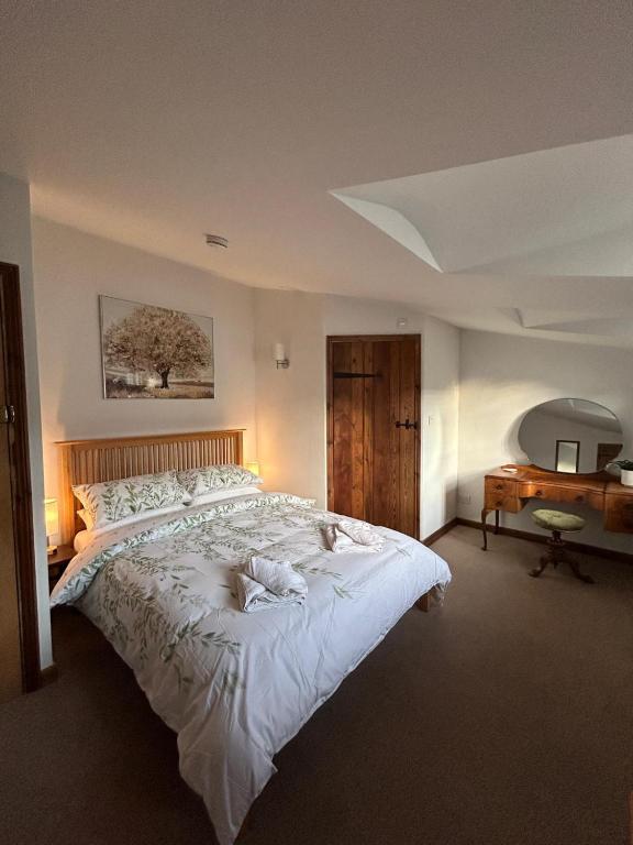 a bedroom with a large white bed and a desk at St Cuthbert's Keep in Bedford