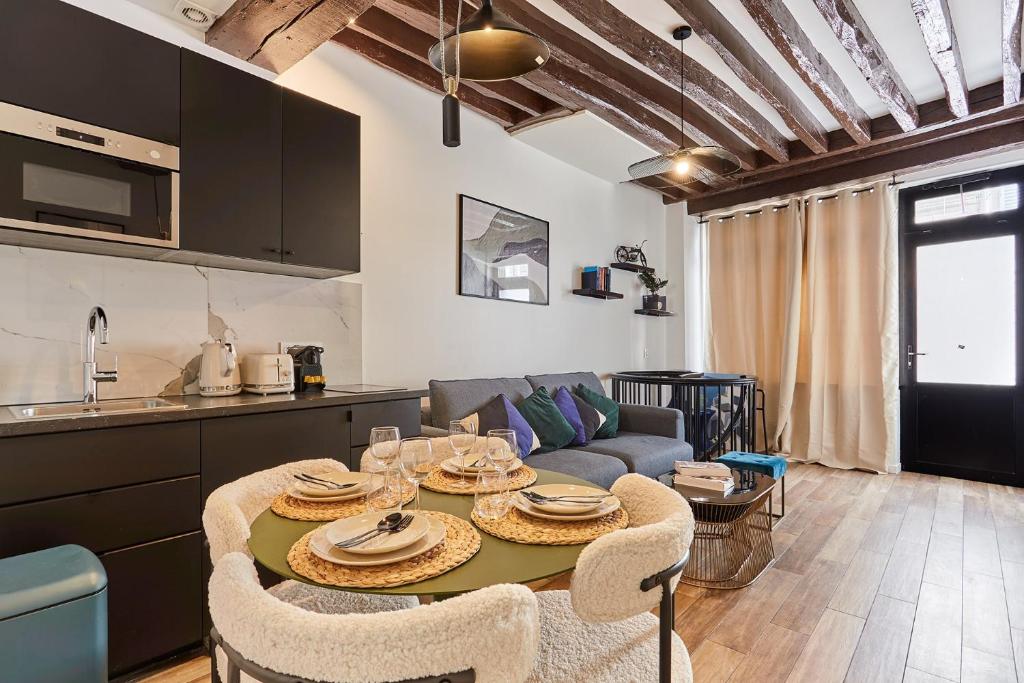 une cuisine et un salon avec une table et des chaises dans l'établissement Duplex in the center of Paris, à Paris