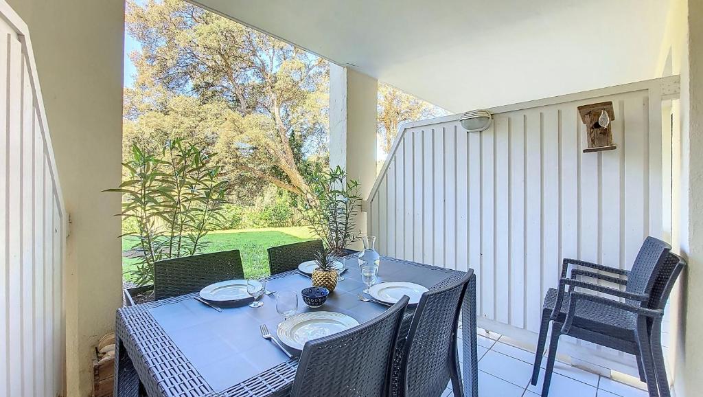 - une table bleue et des chaises sur une terrasse couverte avec une fenêtre dans l'établissement M- Albatros 04-Moliets Appartement 2 pièces avec terrasse proche golf, à Moliets-et-Maa