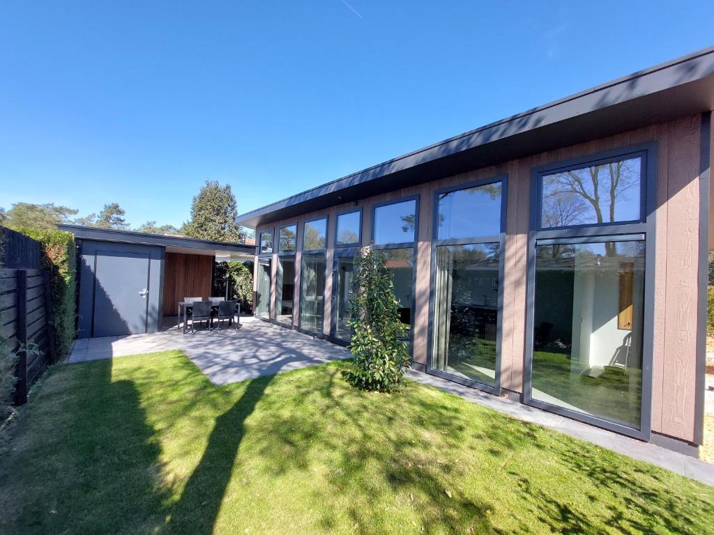 a house with large windows and a yard at Comfort bungalow 02 in Putten