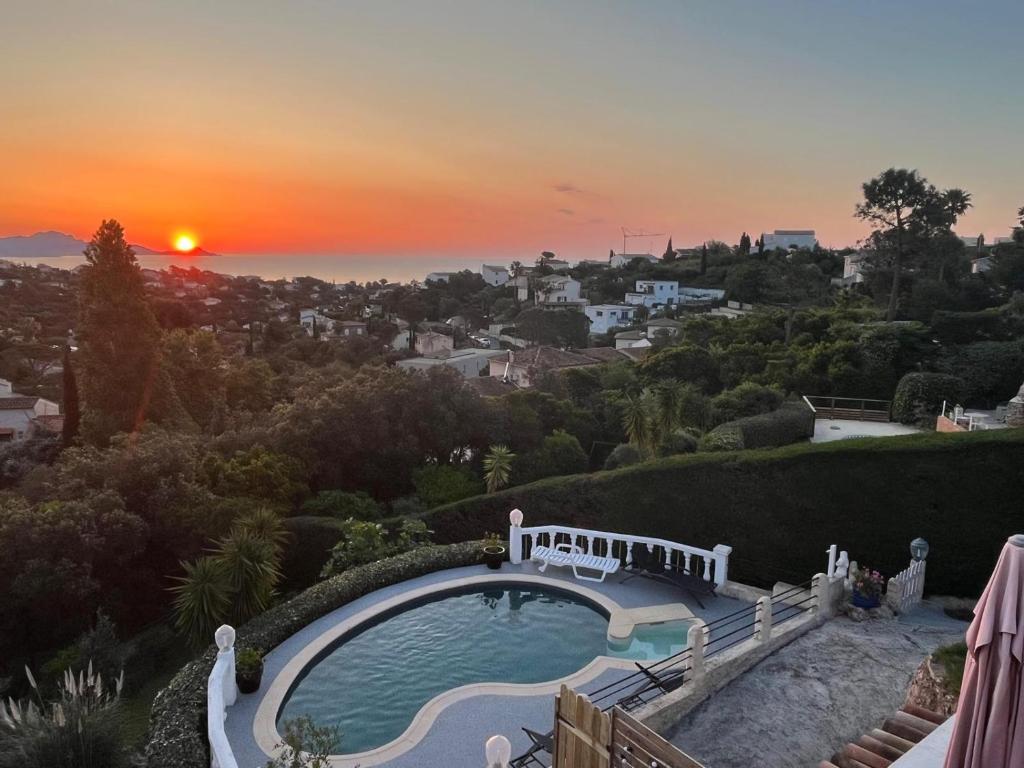 une piscine avec un coucher de soleil en arrière-plan dans l'établissement L'éveil Marin, à Roquebrune-sur Argens