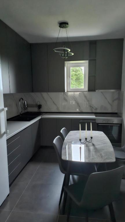 a kitchen with a table and chairs and a sink at Nuko's family in Nikšić