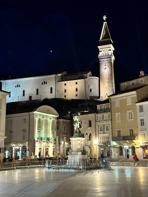 a large building with a clock tower at night at Apartma Studio Enej Piran in Piran