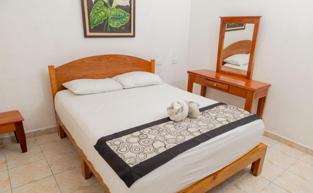 a bedroom with a bed and two tables and a mirror at Hotel Las Palmas en Laurel in Cancún