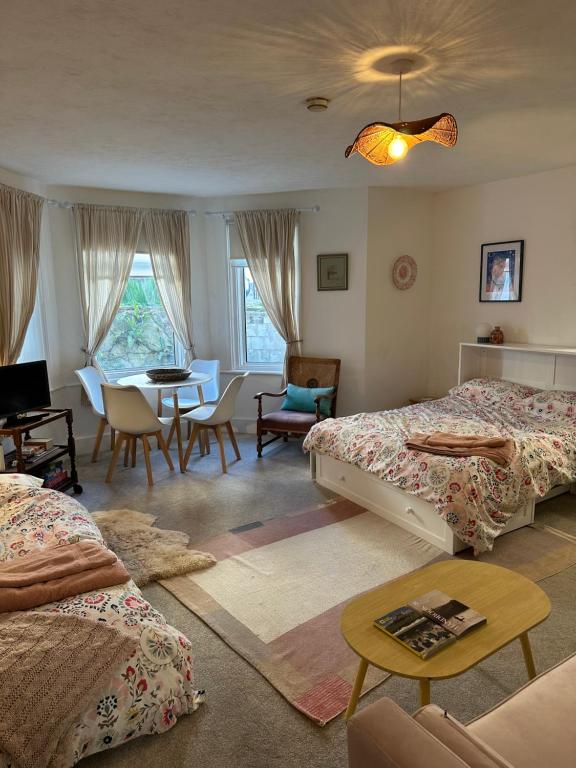 ein Schlafzimmer mit zwei Betten und einem Tisch und Stühlen in der Unterkunft Home By The Sea in Eastbourne