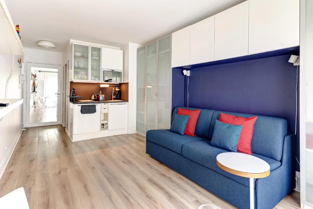 un salon avec un canapé bleu et une cuisine dans l'établissement BM-2Person cosy avec terrasse, à Paris