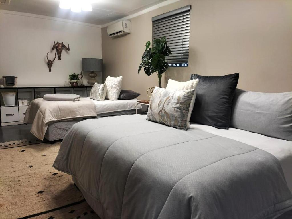 a living room with two beds and a couch at Magalies B&B SPITSKOP in Bloemfontein