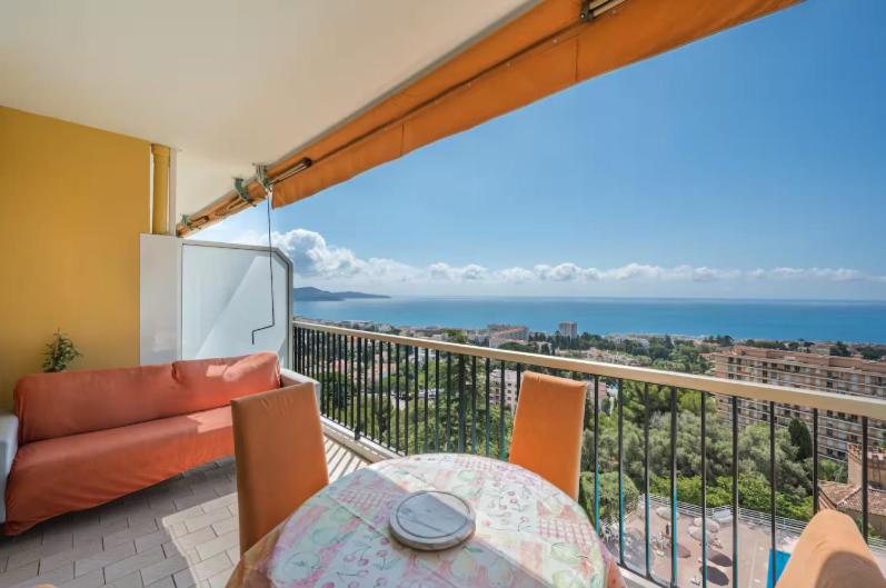 un balcon avec une table et une vue sur l'océan dans l'établissement Le rêve bleu, à Nice