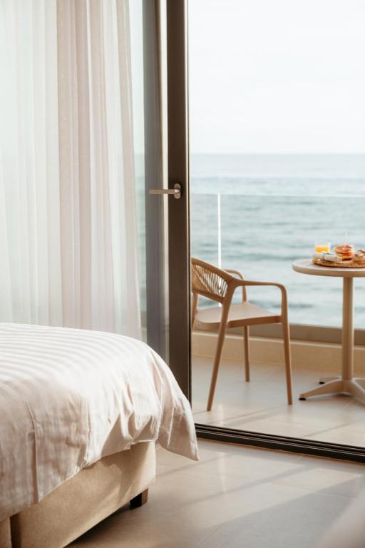 a bedroom with a bed and a table and a chair at Hotel Galaxias in Paralia Katerinis