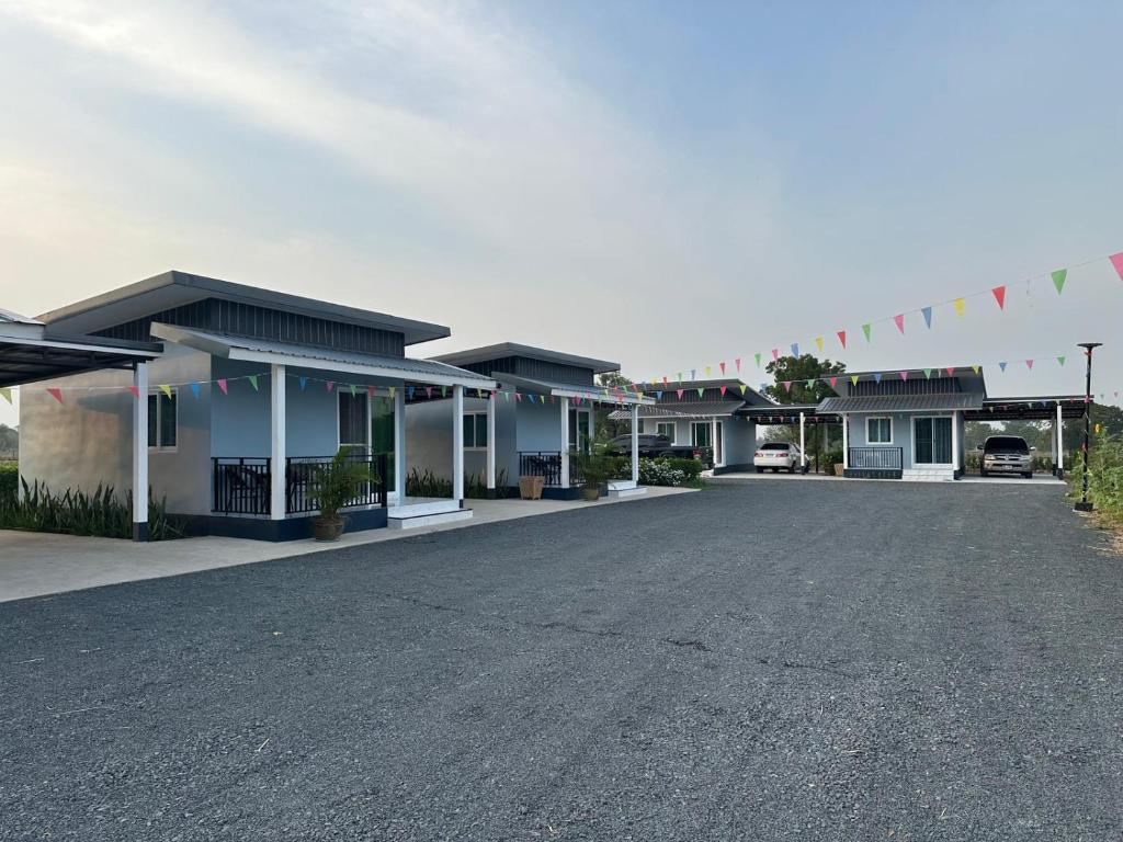 een rij huizen met vlaggen en een parkeerplaats bij Layla Garden resort in Ban Hua Na