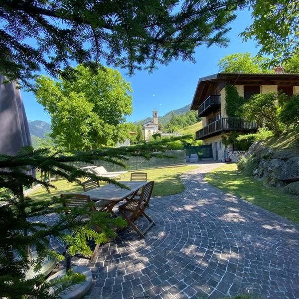 a park bench sitting on a brick walkway next to a building at Chalet Giulia in Bezzecca
