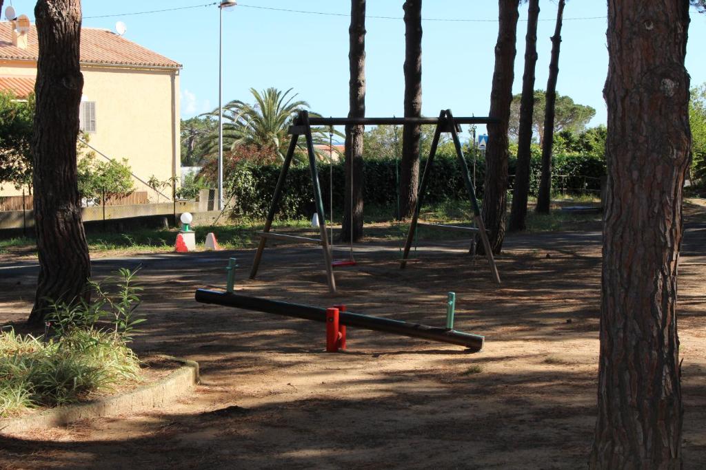 an empty swing set in a park with trees at Résidence Tramariccia in Calvi