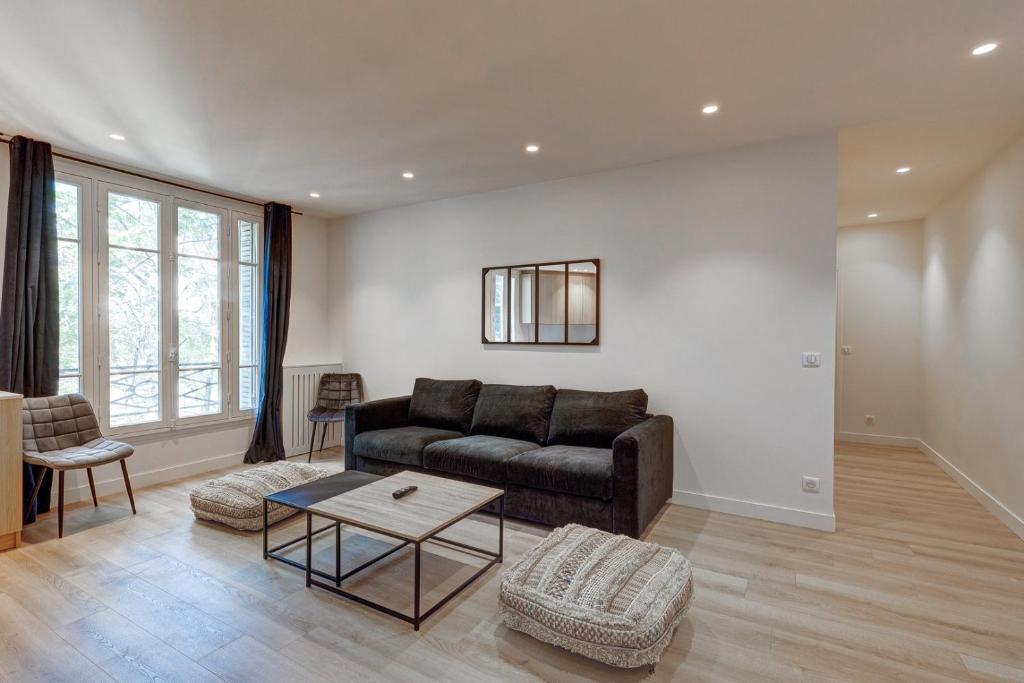 un salon avec un canapé et une table dans l'établissement 563 Suite Maillot - Superbe Appartement à Paris, à Paris