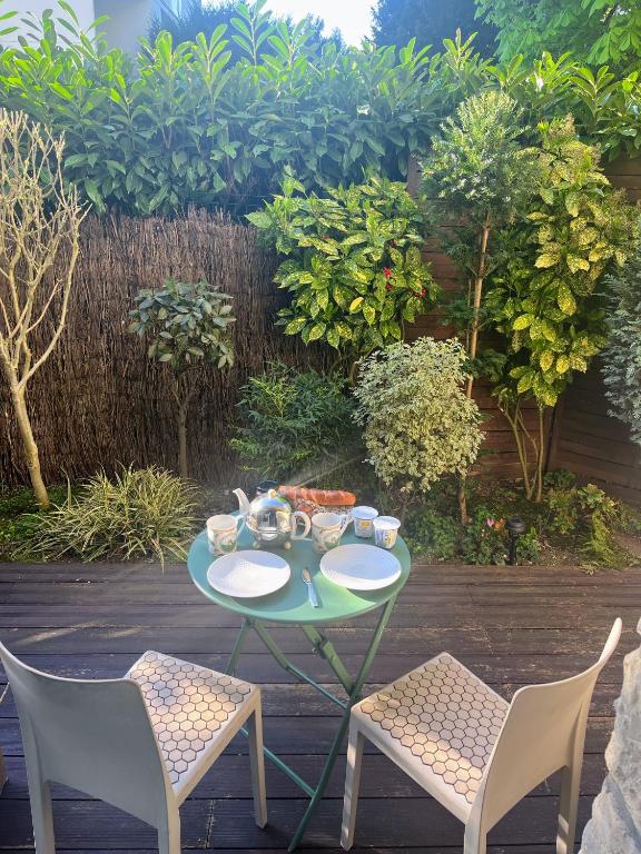 une table et deux chaises avec de la nourriture dans l'établissement Chambre avec jardin proche Paris, à Saint-Cloud
